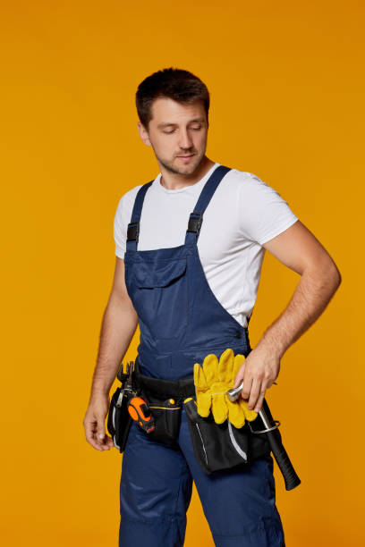 istock repairman worker in yellow hard hat and uniform holding hammer. 1269687283