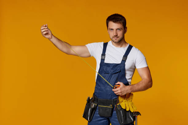 istock repairman worker in uniform holding measure tape. 1269687333