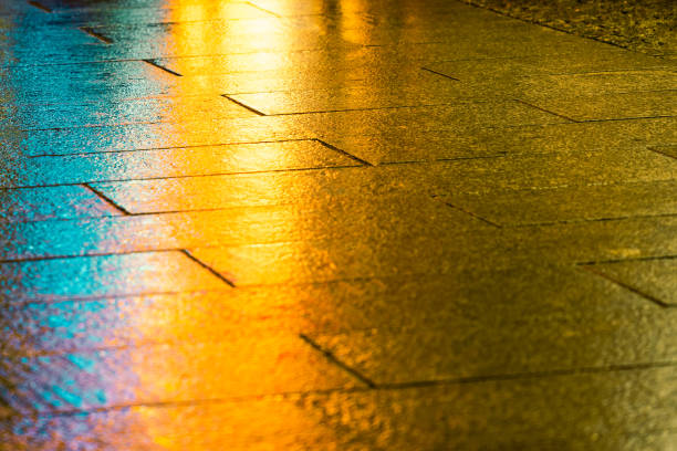 Reflection of bright colored light on the pavement at the evening