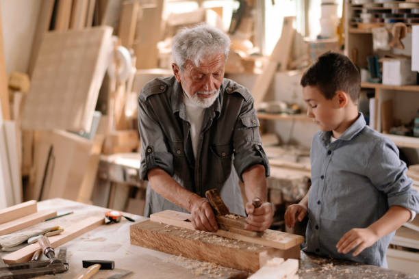istock Senior carpenter and his grandson having fun in the workshop 1269692895