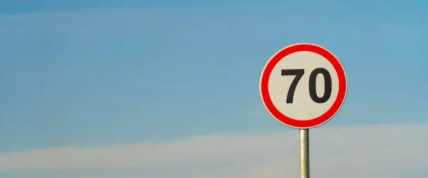 70 speed limit road sign over blue sky background