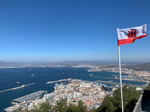 View of Gibraltar from the top of the rock with flag in foreground and Spain in background