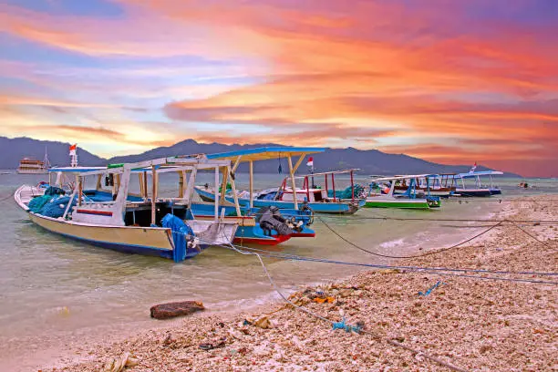 Traditional boats on Gili Meno island in Indonesia at sunset
