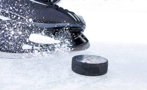 hockey skate with snow splashes and puck - ice skates imagens e fotografias de stock