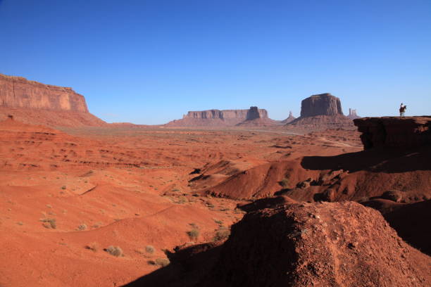 A woman riding on Horse  from John Ford's Point overlook in Monument Valley Tribal Park in Arizona, USA A woman riding on Horse  from John Ford's Point overlook in Monument Valley Tribal Park with the mittens and Merrick Butte in Arizona, USA merrick butte photos stock pictures, royalty-free photos & images