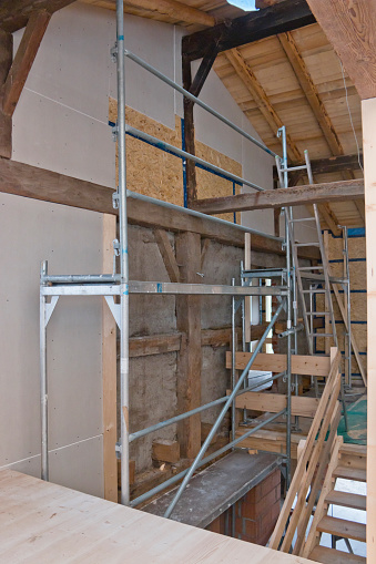 Restoration of an old farmhouse from inside. Picture shows installation of drywall and chipboards and the renewal of beams.