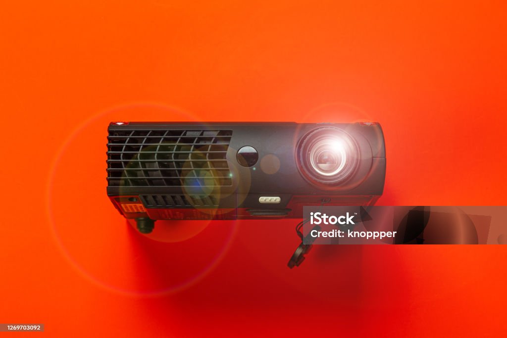 projector on red background glowing cinema projector on red background Film Projector Stock Photo