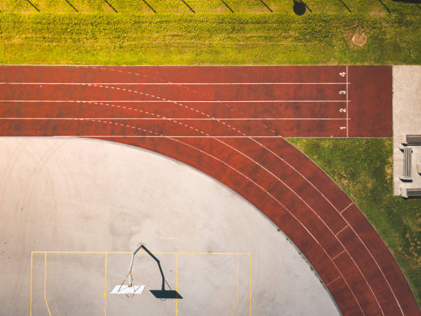 Top view of a numbered running tracks at sports athletic stadium Aerial view of a sports athletic and recreational centre or stadium with basketball court, football field, beach volley and running tracks. track and field stadium stock pictures, royalty-free photos & images