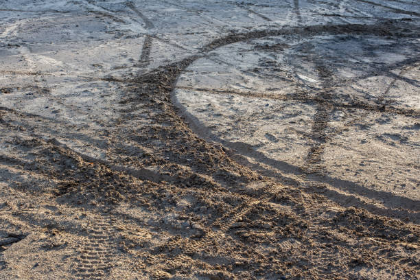 areia seca e chão de lama com muitas faixas de bicicleta de terra à luz do dia - mud road tire track footpath - fotografias e filmes do acervo