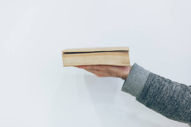 istock Man holding close old paper book 1269708703