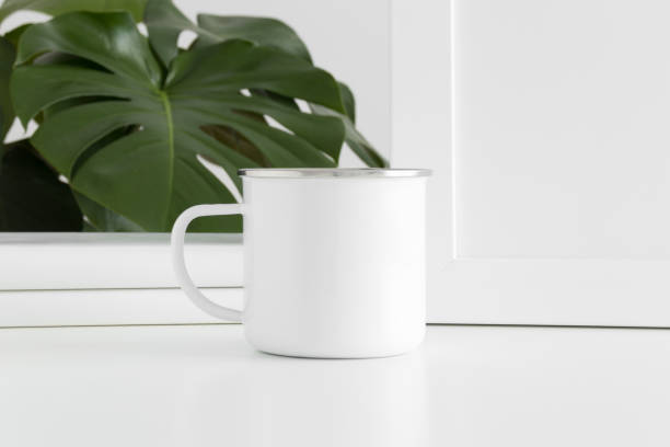 istock Enamel mug mockup with workspace accessories and a monstera plant. 1269708875