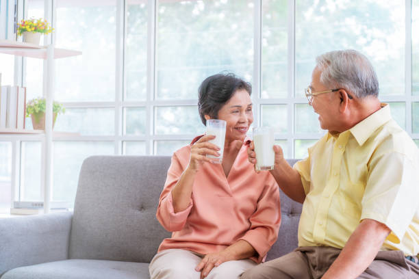 istock Two senior couple is drinking milk while relaxing on a sofa living room for retiredment wellness and healthy lifestyle concept. 1269708953