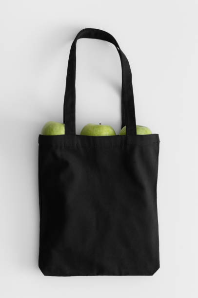 istock Black tote bag mockup with fruit on a white table. 1269711100
