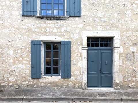 Stone built French house with grey window shutters