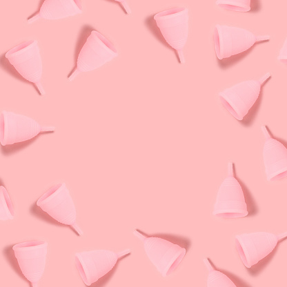 Las copas menstruales enmarcan sobre un fondo rosa. photo