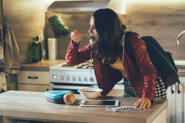 High school student in a hurry for school, eating breakfast at home Teenage high school student in a hurry for school while eating breakfast at home and hurrying for school bus instant food stock pictures, royalty-free photos & images