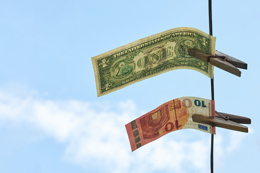 Dollars and euros are hanging on a rope, as a symbol of competition between currencies, concept, copy space