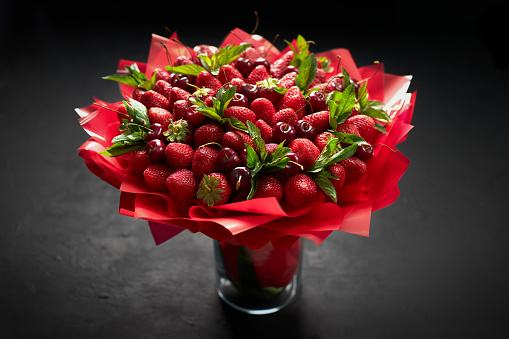 Beautiful bouquet of ripe strawberries and cherries on a black background
