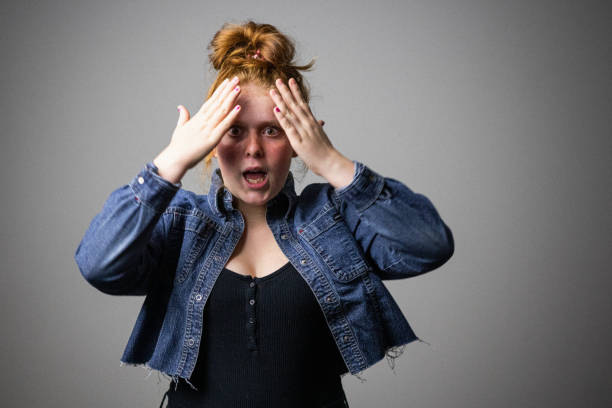 Oh no, I completely forgot! A flustered redhead teenager just realized that she forgot a very important task, may that be her homework, household chores or an appointment. Series representing the different moods of a teenage girl. rosy cheeks stock pictures, royalty-free photos & images