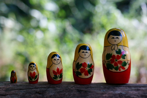 Nesting dolls stand in a row on a colored background. Background image. Concept symbol.