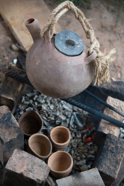 istock A steaming teapot and tea cups. Tea preparation in a clay pot on a fire. A camping trip, a journey. 1269722648