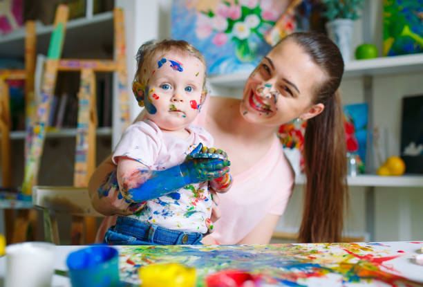 描画学校のキャンバスにママと娘の絵を描く - artists canvas indoors childhood small ストックフォトと画像