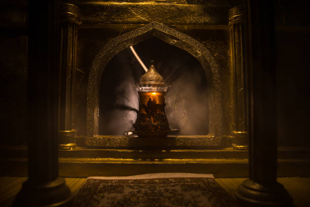 istock Arabian tea in glass inside room. Low light lounge interior with carpet. Selective focus 1269724805
