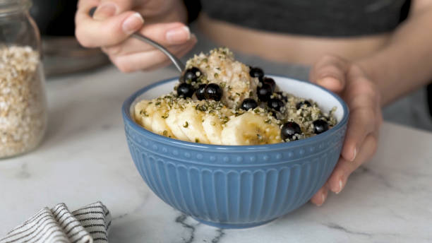 фитнес-женщина ест веганскую овсяную кашу на завтрак - oatmeal heat bowl breakfast стоковые фото и изображения