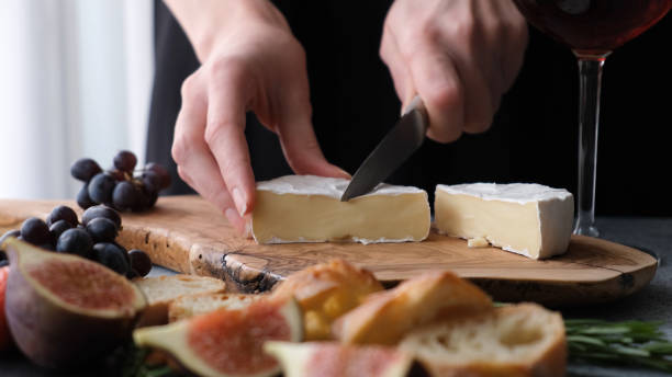 istock Preparing cheese plate with soft camembert cheese, figs and grapes 1269727124