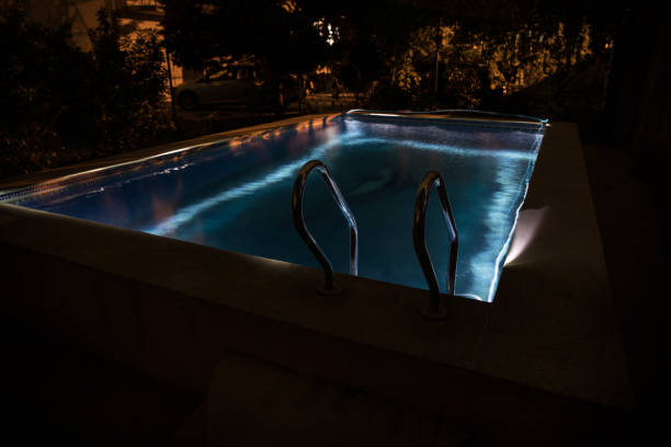 istock Pool and waterfall at night - vacation background. Colorful light decoration. Freezelight 1269727230