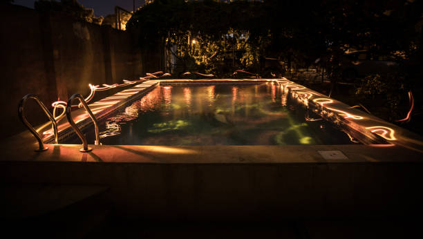 istock Pool and waterfall at night - vacation background. Colorful light decoration. Freezelight 1269727236