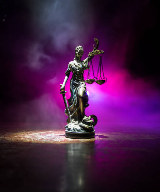 die statue der gerechtigkeit - dame gerechtigkeit oder iustitia / justitia die römische göttin der gerechtigkeit auf einem dunklen feuer hintergrund - iustitia stock-fotos und bilder