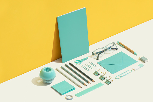 Stationary flat lay on yellow and white background. Blue office, school supplies on yellow and white background.