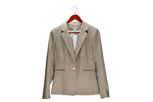 Women's jacket in a houndstooth on a hanger isolated on white background.