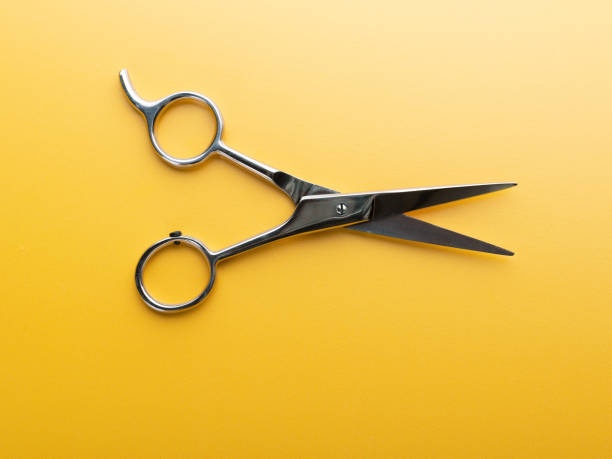 istock Professional haircutting scissors or shears isolated on yellow background 1269729360