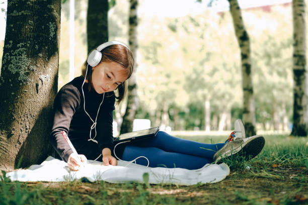 istock happy girl using digital tablet in the park 1269729408