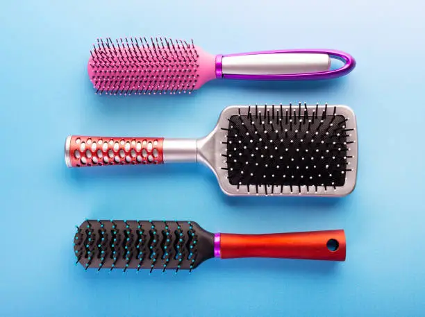 Photo of Comb brushes set. Different hairbrushes for female hair on blue background