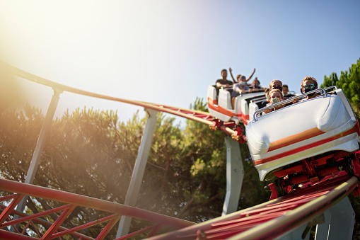 Happy kids having fun in an amusement park riding on a fun ride and screaming - lifestyle concepts