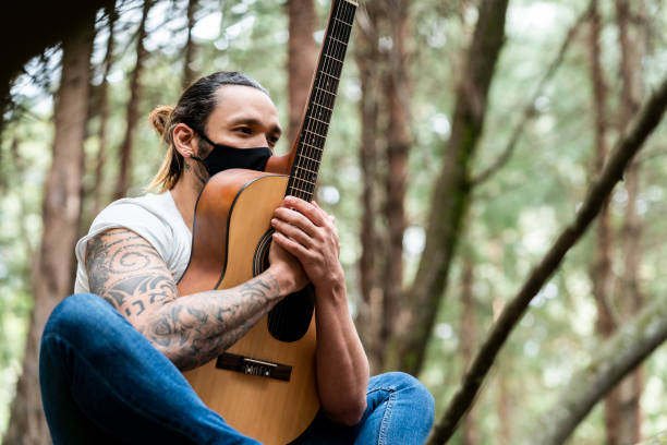 istock Latin man plays his guitar in a forest alone 1269731086