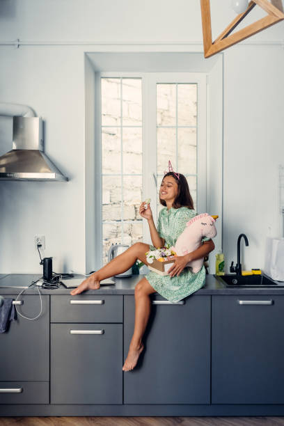 istock Young pretty woman eating cake in modern kitchen. 1269731218