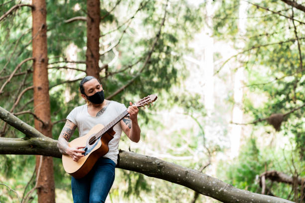 istock Latin man plays his guitar in a forest alone 1269731319