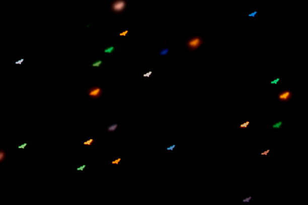Halloween background. Defocused bokeh multicolor lights in shape of bats on black background.