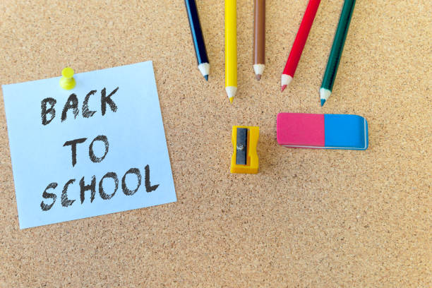 istock Back to school on blue note with color pencils on cork board background with copy space 1269738985