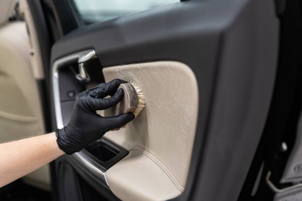 istock Man cleaning car leather interior with brush. 1269741447