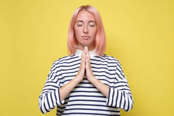 istock Beautiful casually dressed young woman keeping eyes closed while meditating, feeling relaxed 1269743297