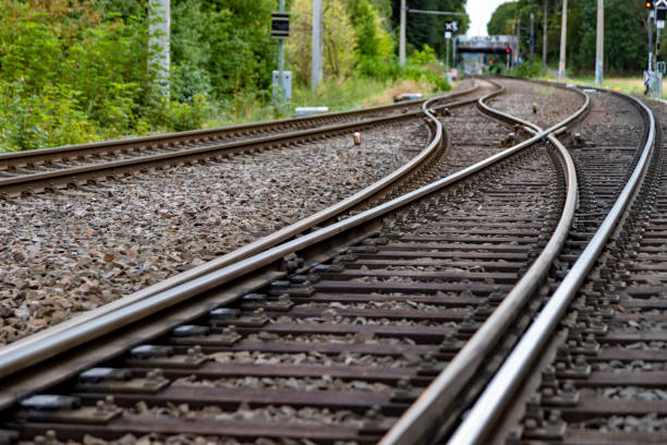 istock railroad tracks in a countryside surroundes by trees, electrical overhead line, with a switch 1269743318