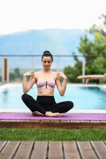 istock Female Meditating By The Pool After Yoga Workout 1269743472