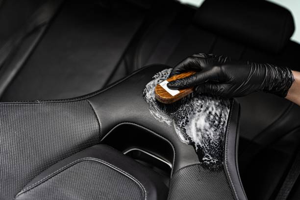 istock Man in rubber gloves cleaning leather car seat 1269744149