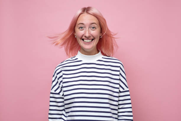 istock Happy young woman with pink dyed has tender smile, looks with charming expression 1269744458