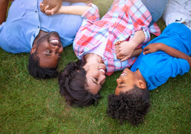 istock Multicultural mixed race multi-ethnic family with one child laying on grass laughing 1269747203